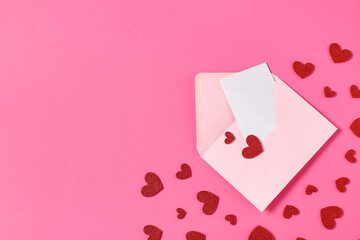 Composition with envelope, card and red hearts on pink background. Valentine's Day celebration