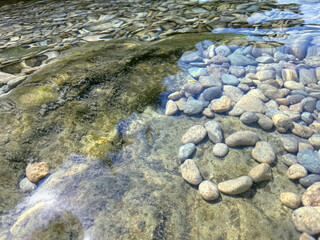 Sea pebbles and stones in clear water.