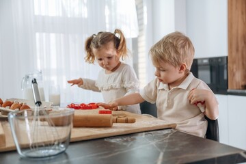 Red bakeware. Kids are preparing bakery at home