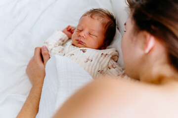 Close-up of newborn sleeping next to mother, tender connection