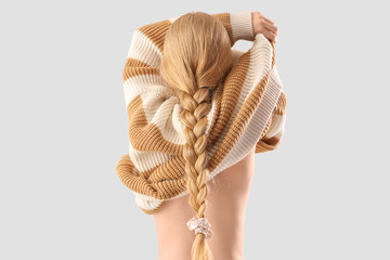 Fototapeta premium Beautiful young woman taking of sweater on white background