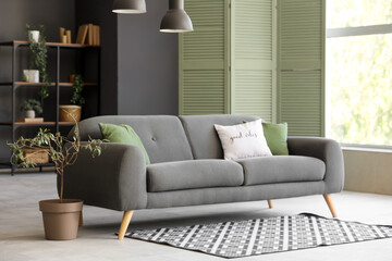 Comfortable sofa, carpet and hanging lamps in living room