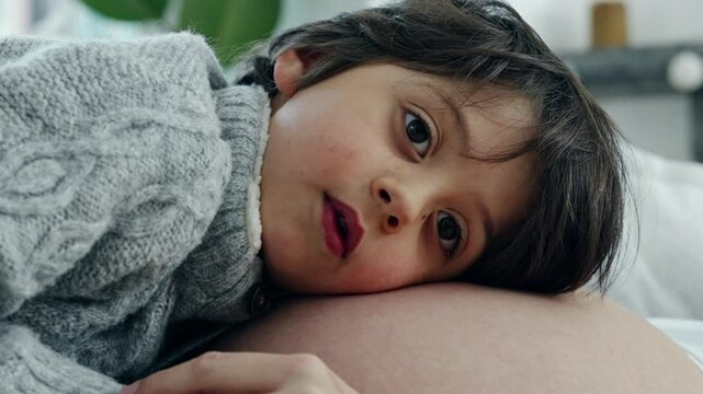 Intimate Maternity Moment - Young Son Attuned to Mother's Belly, Feeling Baby's Movement, Relaxed Pregnant Woman Lying on Sofa, Deepening Family Bonds in Home Setting