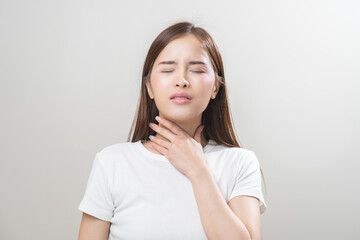 Sickness in inflaming asian young woman, girl use hand check self touch at sore throat, pain thyroid gland on neck or disease reflux, acid of suffer people on wall background. Medical and healthcare.
