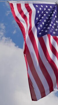 Vertical Hanging Waving USA flag, close up, low angle