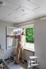Carpenter installing a new window in a family house during renovation and refurbishment.