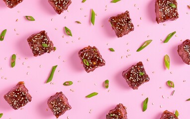 Korean BBQ short ribs with sesame and green onions, beautifully presented on a pastel pink...