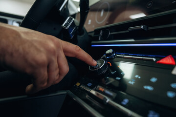 Pressing the button. Man is sitting in car, detailed view