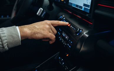 Fototapeta premium Pressing the button. Man is sitting in car, detailed view