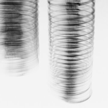 Abstract of metal coiled slinky, length of fine wire wound around and stretched, black and white image.