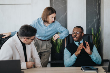 A multicultural group of business people interacting in a modern office. The image captures collaboration and teamwork, showcasing a dynamic exchange of ideas in a professional setting.