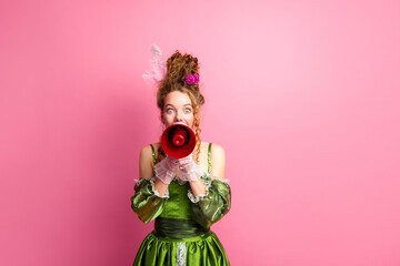 Young Woman in Green Historic Costume Calling with Megaphone Against Pink Background
