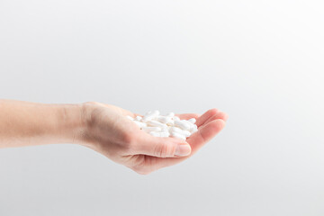 A hand full of white pills in a woman's hands. Concept of health care, dietary supplements, treatment of depression and diseases. High-quality photo banner