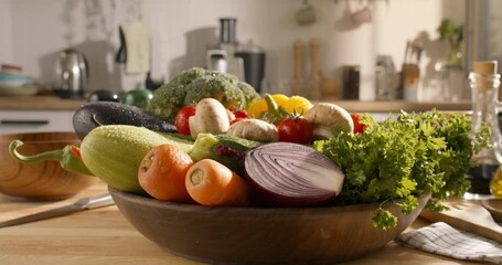 Set of fresh vegetables in bowl, summer raw vegetarian healthy meal. Fresh vegetables in a wooden plate on the table in the bright kitchen. Broccoli, carrots, red onion, zucchini, mushrooms, lettuce. - Powered by Adobe