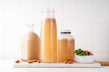 Homemade almond Orgeat Syrup in different bottles, almonds, water, sugar, and orange flower water syrup for making sweet cocktails