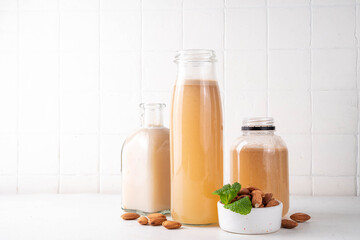 Homemade almond Orgeat Syrup in different bottles, almonds, water, sugar, and orange flower water syrup for making sweet cocktails