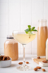 Sweet and sour lemon orgeat cocktail, Orgeat Lemonade Recipe, one martini glass with alcohol boozy drink and almond orgeat syrup bottle