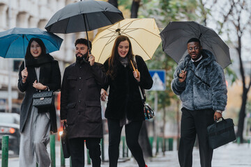 A cheerful group of individuals under umbrellas walking together through a city in the rain,...