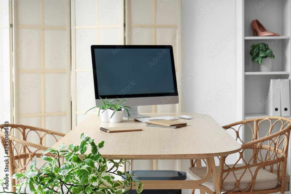 Poster workplace with blank computer monitor and notebooks on table in clothing store office