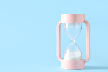 Stylish hourglass with white sand on blue background