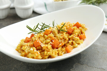 Delicious pumpkin risotto on grey table, closeup