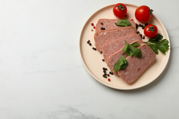 Pieces of tasty canned meat, parsley, peppercorns and tomatoes on white marble table, top view. Space for text