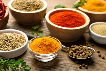 Different aromatic spices on wooden table, closeup