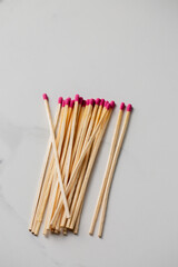 A pile of wooden matches with pink tips