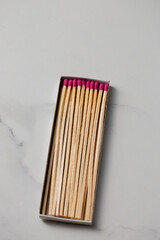 A box of matches with a pink and red head