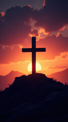 A Christian cross standing against a beautiful sunset over a rocky hilltop.