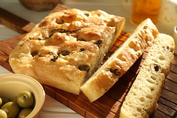 Pieces of delicious focaccia bread with olives and thyme on table, closeup