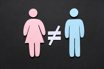 Female and male paper figures with crossed equal sign on black background