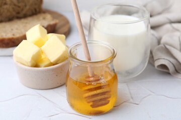 Sweet honey, butter and milk on white table, closeup