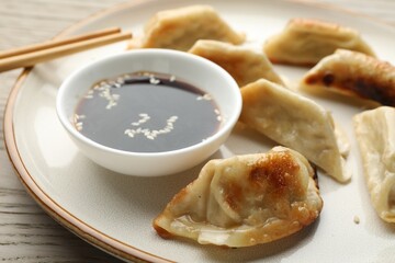 Delicious fried gyoza dumplings served on wooden table, closeup
