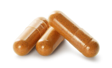 Three turmeric capsules isolated on white. Herbal dietary supplement