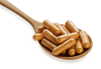 Turmeric capsules in spoon isolated on white