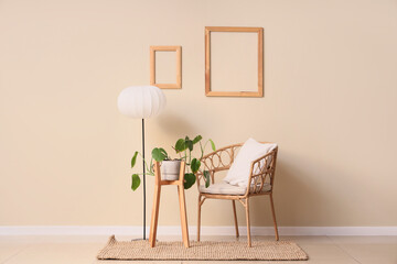 Interior of room with wicker armchair, lamp and houseplant near beige wall