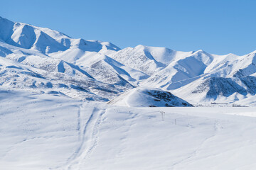 Obraz premium Mountain ranges covered with snow and blue clear sky. Sunny winter day in the mountains.