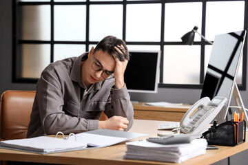 Worried male worker at table in office