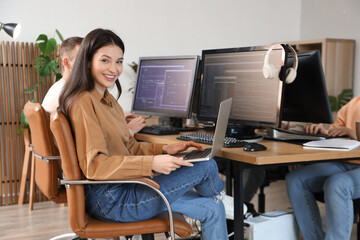 Female programmer working with laptop in office