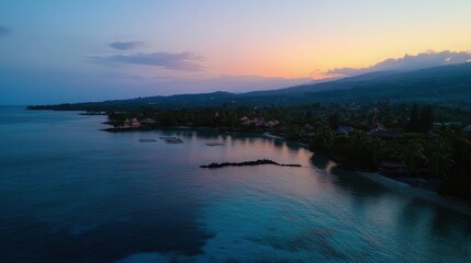 Serene coastal sunset over a tranquil bay with palm trees and distant mountains