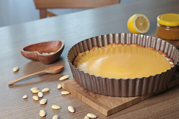 Cake made of almond flour and natural fruit in mold for baking in kitchen. Nuts on table. Healthy food and products. Organic ingredients and vegan nutrition. 