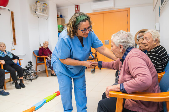 Caring nurse assisting elderly residents in nursing home