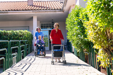 Elderly residents enjoying outdoor walk at nursing home