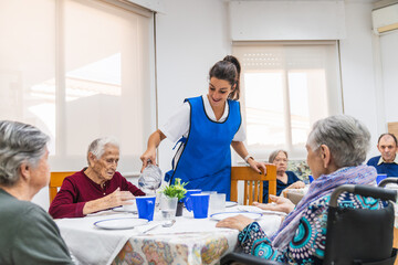 Caring nurse assisting elderly in nursing home