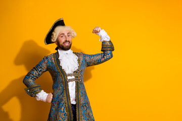 Young man dressed as a historic nobleman flexing in an elegant costume against a vibrant yellow...