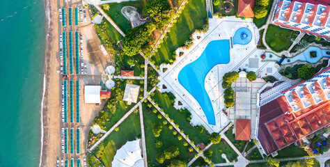 Aerial view of a beachfront luxury resort with pools, gardens, and a private beach
