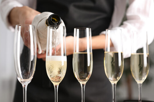 Waiter filling glasses with champagne indoors, closeup - Powered by Adobe