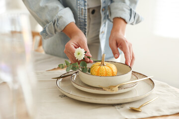 Woman setting table for dinner at home, closeup