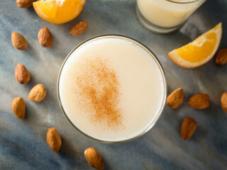 Amaretto sour cocktail top down, milk cocktail with almonds and cinnamon.